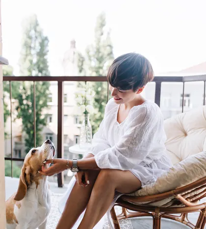 A woman relaxing on her balcony with her dog