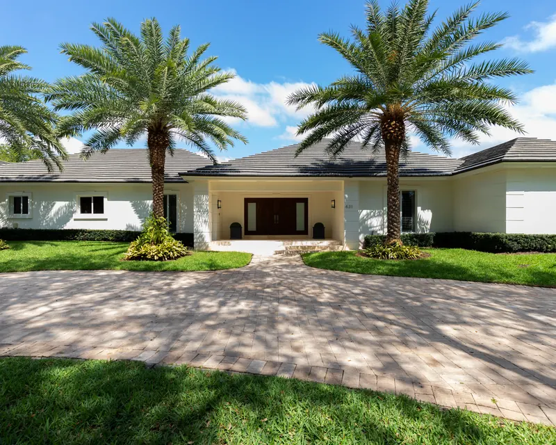 A Florida home framed by tall palm trees on a sunny day